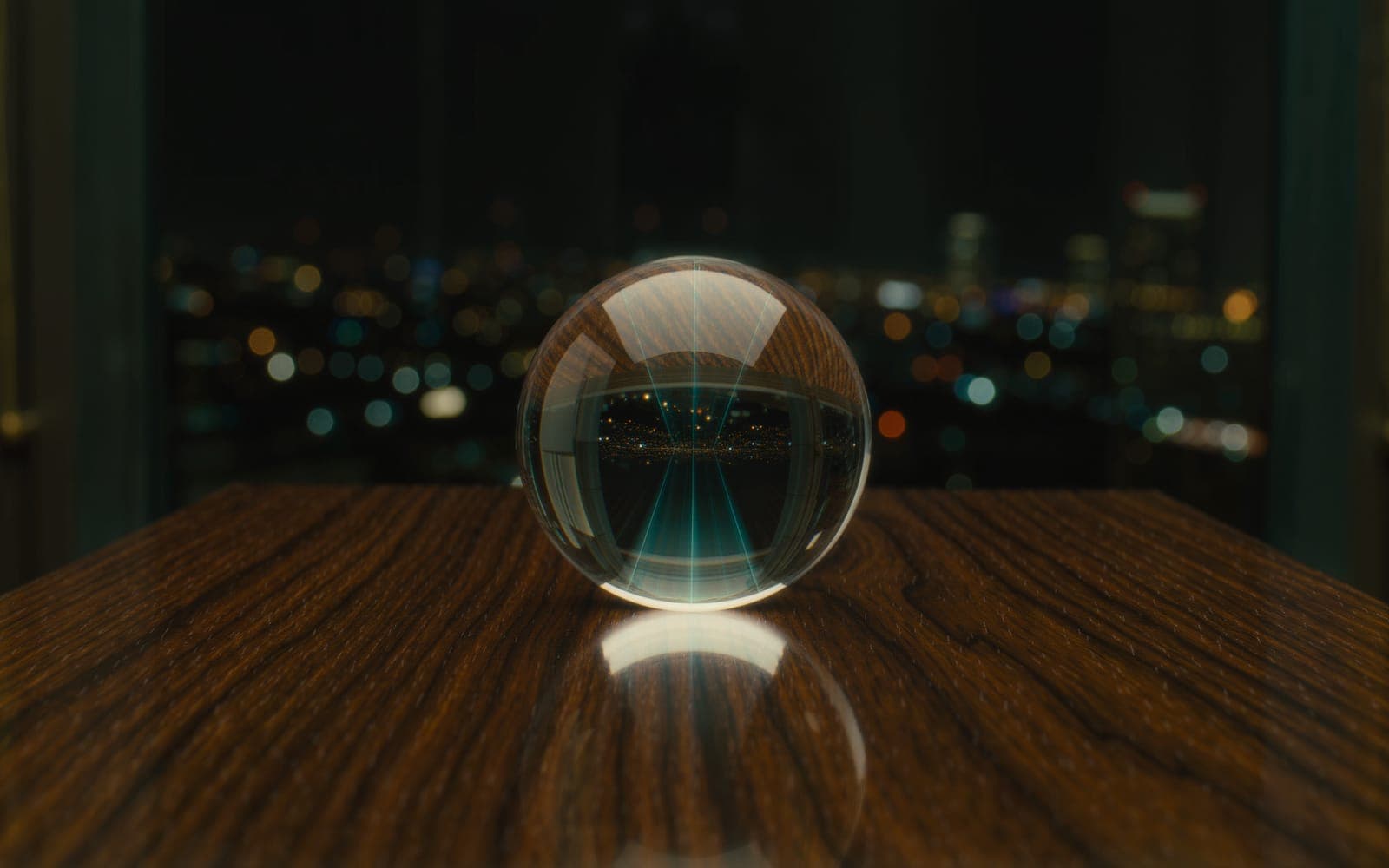 A clear glass sphere on a dark walnut desk refracting window light into prismatic teal and amber with soft points of light behind it