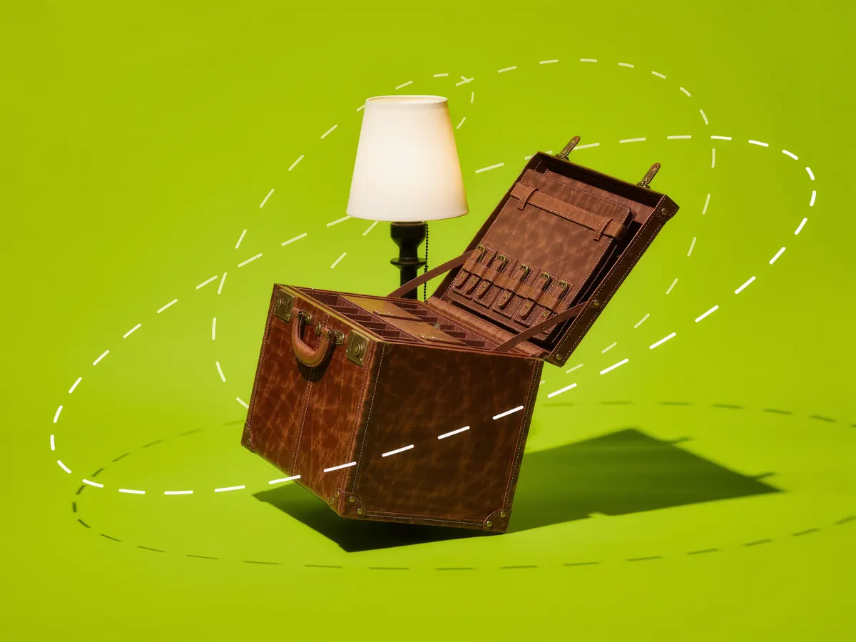 A vintage leather sample case standing open under a small desk lamp on a lime green background.