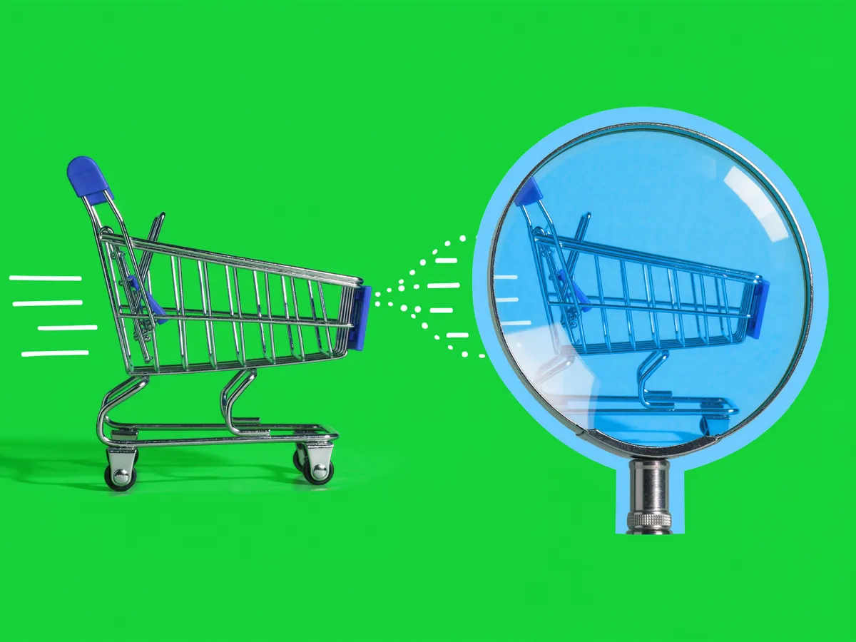 A small shopping cart and a large magnifying glass on a bright green background.