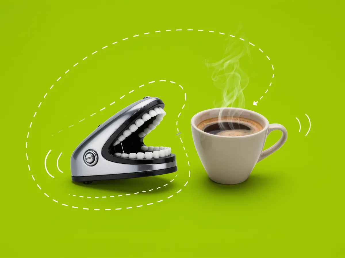 A wind-up chattering teeth toy next to a cup of coffee on a lime green background.
