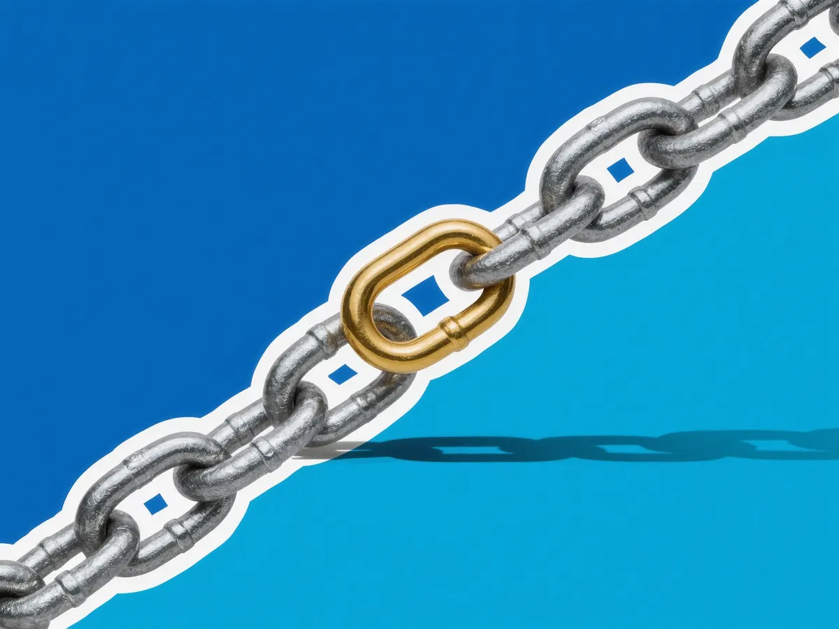 A steel chain with one gold link in the middle.