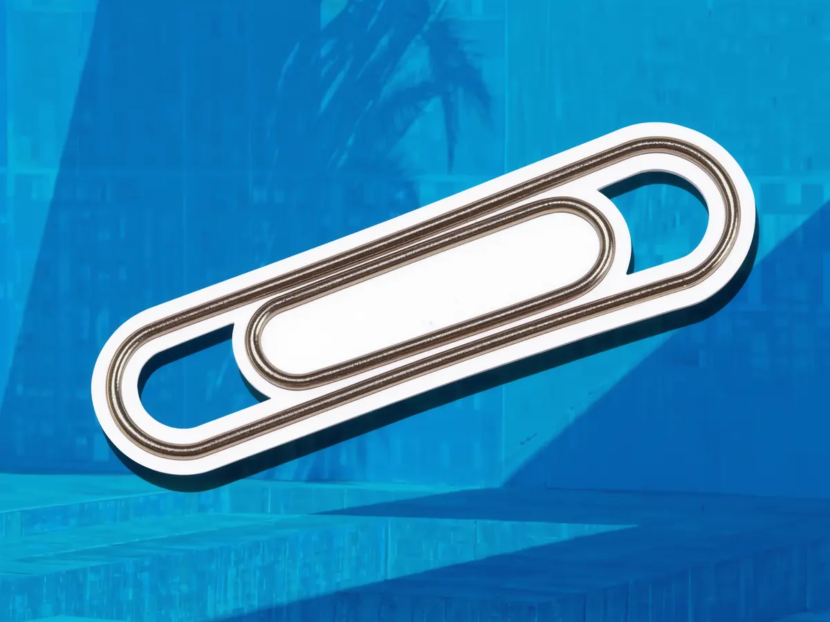 A long chain of oversized metal paper clips, cut out over a blue duotone photograph.