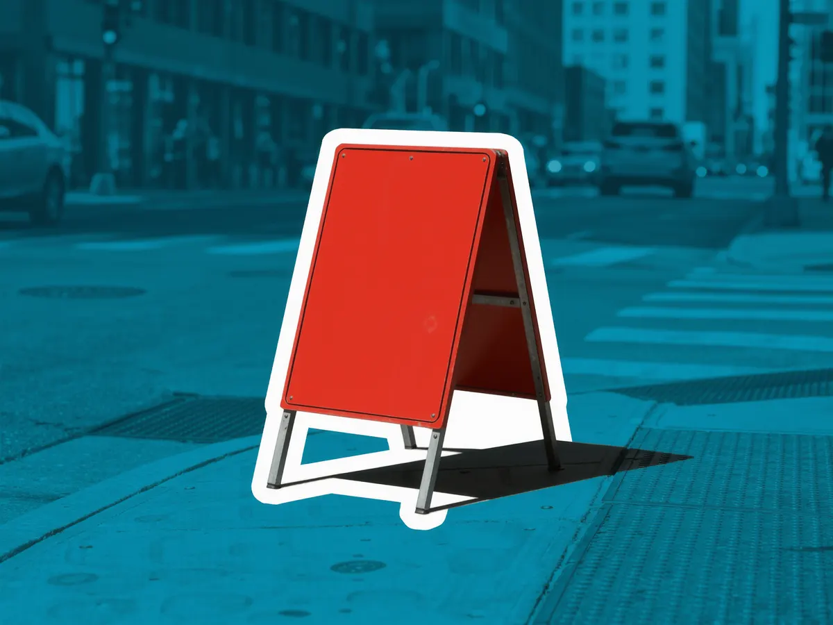 A blank red sandwich-board sign standing on a city sidewalk.