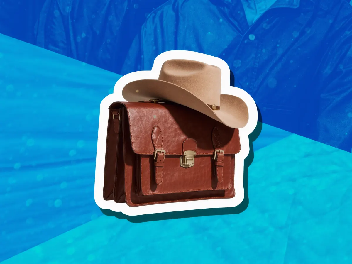 A leather briefcase with a cowboy hat resting on top.