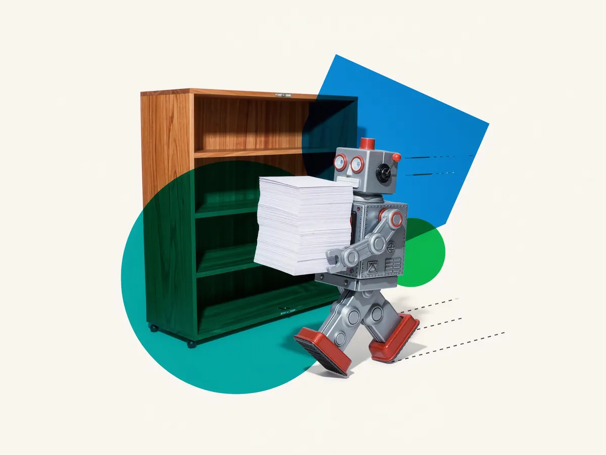 A small tin robot carrying a stack of index cards past a wooden library card catalog.