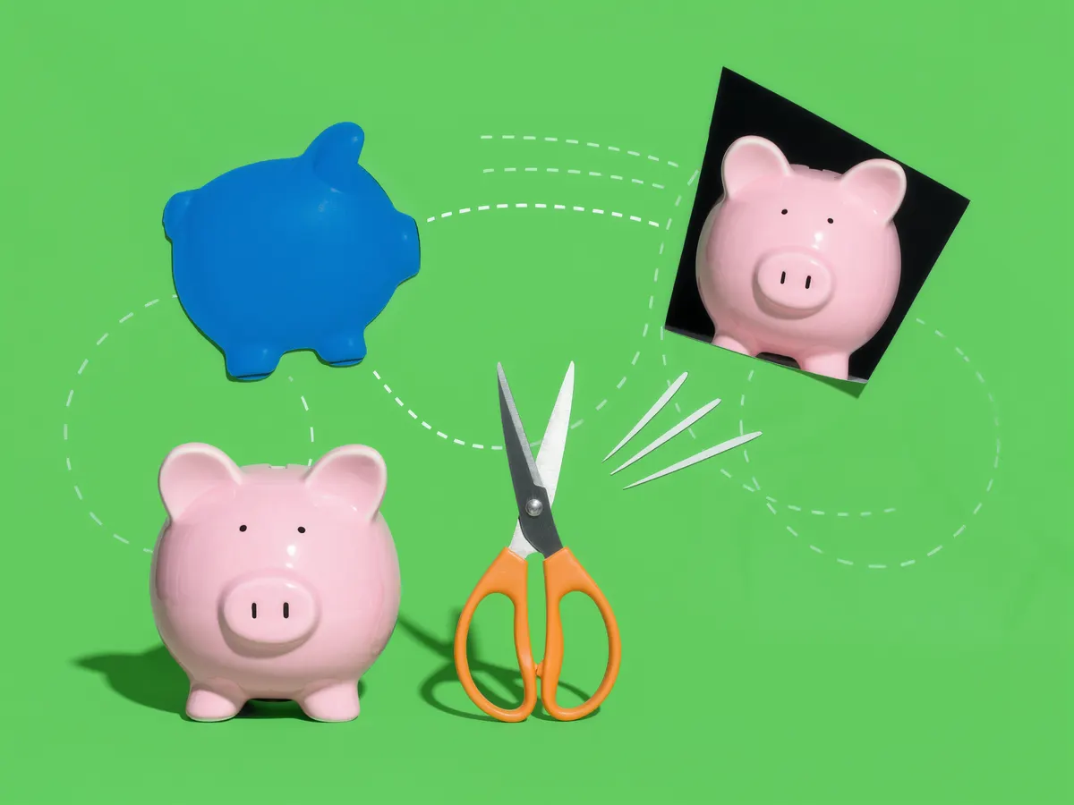 A pink piggy bank and a pair of scissors on a bright green background.